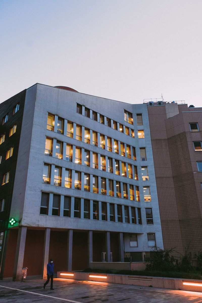 A modern hospital building with lit windows at dusk