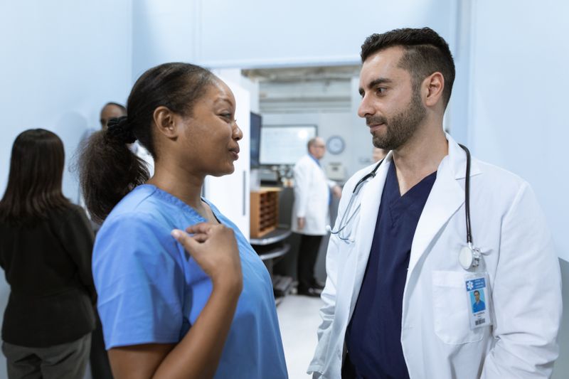 A nurse and a doctor discussing a patient in a hospital corridor