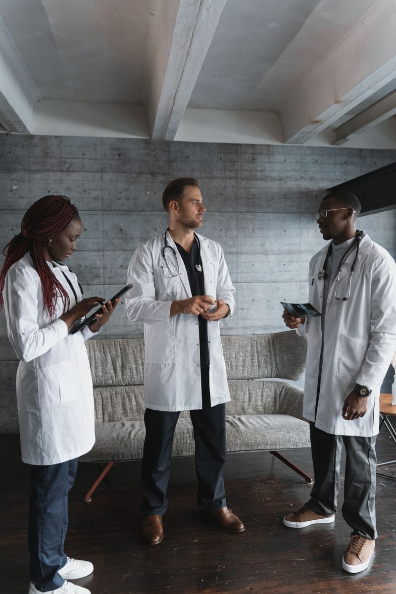 Three doctors with tablets discussing a diagnosis